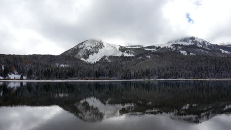Lost-Lake-Spiegelreflexion-Bewölkt-Grau-Dramatisch-Kebler-Pass-Colorado-Filmisch-Frostig-Kalt-Nachmittag-Herbst-Winter-Saison-Kollidieren-Zuerst-Weißer-Schnee-Rot-Gelb-Orange-Espenbaum-Wald-Felsige-Berge