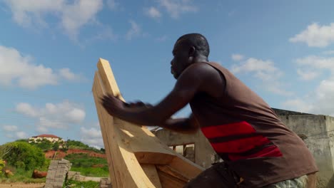 Carpintero-Africano-Nativo-Alisando-La-Proa-Del-Barco-De-Madera-Con-Avión-De-Fregado