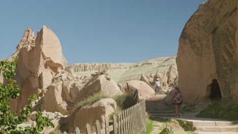 Woman-tourist-walks-rocky-landscape-Zelve-museum-sunny-day