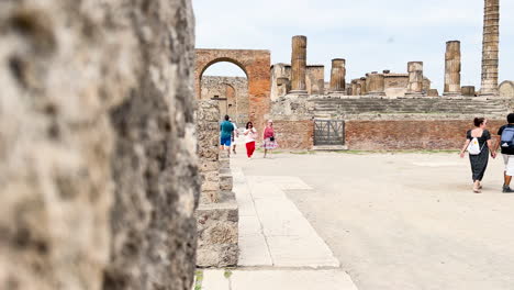 Visitors-walking-through-the-well-preserved-streets-of-Pompeii,-surrounded-by-the-remnants-of-the-ancient-city
