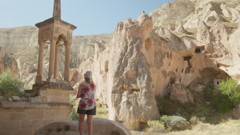 Woman-tourist-visits-manmade-architecture-rocky-landscape-Zelve-museum