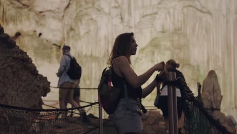 Una-Joven-Asombrada-Camina-Por-Un-Sendero-Dentro-De-La-Gruta-De-Neptuno.