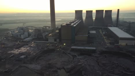 Fiddlers-ferry-power-station-cooling-towers-demolition-debris-aerial-view-tilt-up-to-glowing-sunrise-skyline