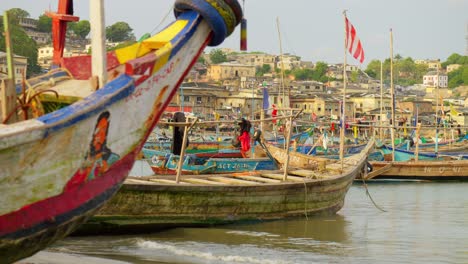 Fishing-boats-in-shallow-water-by-beach-at-Cape-Coast-harbor-in-Ghana