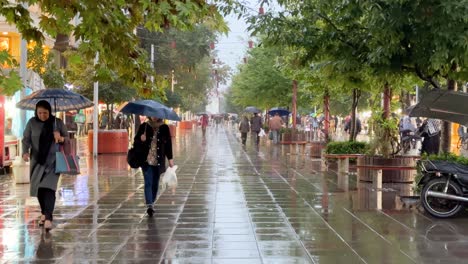 Gente-Caminando-En-Un-Día-Lluvioso-Crepúsculo-Tarde-En-La-Ciudad-Lluvia-Caída-Día-Lluvioso-En-La-Noche-Paisaje-Urbano-De-La-Ciudad-Tiro-Escénico-Reflejo-De-Luz-Limpio-Destino-Turístico-Viajar-A-Rasht-Gilan-En-La-Cultura-De-Irán