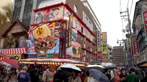 Busy-Crowds-With-Umbrellas-Walking-Through-Shinsekai-Area-On-Rainy-Day