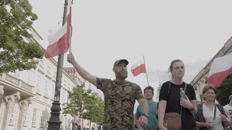 Toma-Cinematográfica:-Orgulloso-Patriota-Polaco-Caminando-Y-Sosteniendo-En-Alto-La-Bandera-Polaca