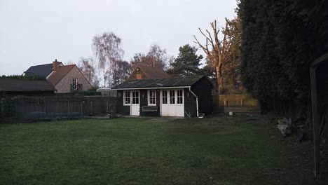 Gartenhaus-In-Einem-Wunderschönen-Grünen-Garten,-Bei-Sonnenuntergang,-Dunkle-Umgebung