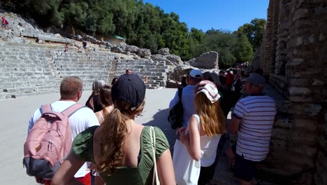 Overflowing-Crowds-of-Tourists-Amidst-the-Ancient-Amphitheater-in-Butrint,-a-Captivating-Archaeological-Site-Adventure