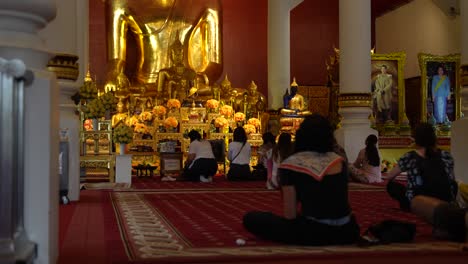 People-praying-in-the-Wat-Phra-Singh-temple-at-Chiang-Mai,-Thailand