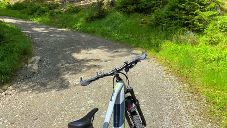 Sporty-electric-mountain-bicycle-in-a-beautiful-sunny-green-forest,-fun-summer-adventure-day-sport-activity-in-Serfaus-Fiss-Ladis-bikepark,-biking-in-Tyrol-Austria,-4K-shot