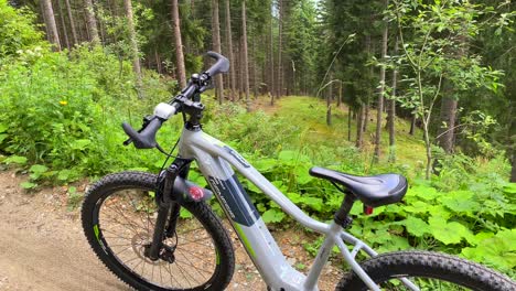 Sporty-electric-mountain-bicycle-in-a-beautiful-green-forest,-fun-summer-adventure-day-sport-activity-in-Serfaus-Fiss-Ladis-bikepark,-bike-in-Tyrol-Austria,-4K-shot