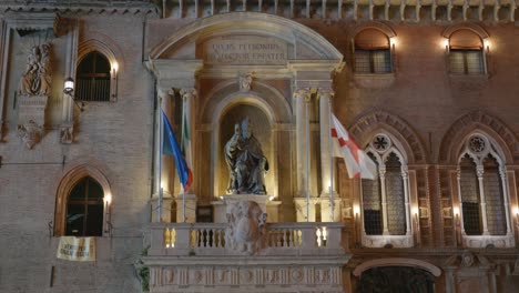 Statue-of-Pope-Gregory-XIII-disguised-as-Saint-Petronius-in-Bologna-on-the-facade-od-Palazzo-d-Accursio-at-night