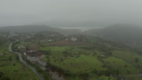 The-drone-is-moving-towards-the-camera-side,-where-a-small-river-is-visible-in-the-middle