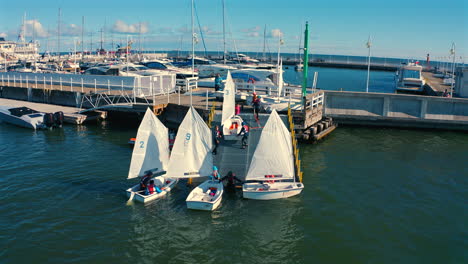 Optimist-dinghy-boats-sailing-into-the-marina-in-Sopot,-Poland-at-sunny-vacation-day