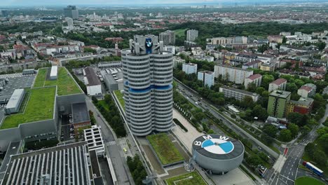 Aerial,-cinematic-view,-BMW-Museum-and-the-Munich-city-skyline-beyond
