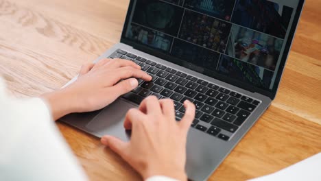 Businesswoman-scrolling-through-stock-footage-pictures-on-laptop-screen