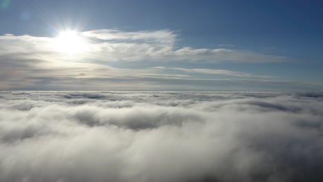 Vista-Aérea-Del-Cielo-Con-Una-Densa-Cama-De-Nubes-Blancas-Y-Un-Sol-Brillante-Arriba