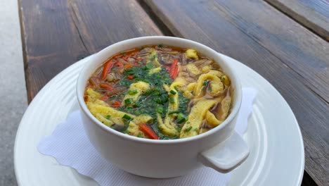 Traditional-Austrian-Frittatensuppe-in-a-bowl-in-Tyrol-Austria,-delicious-hot-comforting-soup-in-Serfaus-Fiss-Ladis,-4K-shot