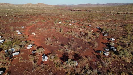 Aerial-tilt-down-shot-over-Dales-Campsite-in-red-desert-of-Karijini-National-park-at-sunny-day-in-Australia
