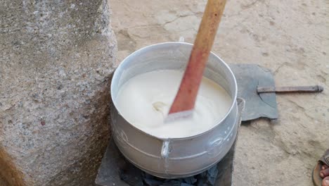 White-banku-mixture-stirred-in-a-pot-on-a-charcoal-stove,-national-dish-of-Ghana
