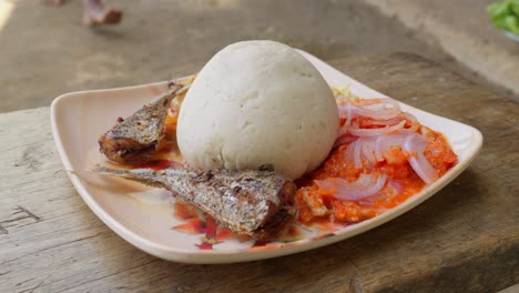 Delicious-typical-lunch-in-Ghana,-banku-dumpling-accompanied-by-fish-and-stew