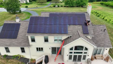 Residential-house-with-solar-panels-and-an-employee-installing-black-array