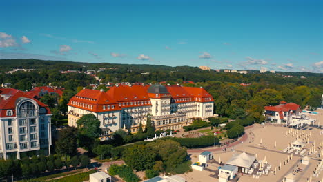 Aerial-view-of-drone-flying-above-the-Grand-Hotel-and-beach-in-Sopot,-Poland-at-sunny-summer-day