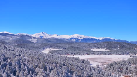 Navidad-Primera-Nieve-Hojas-Perennes-Tres-Hermanas-Rango-Frontal-Monte-Denver-Cielo-Azul-Evans-Aéreo-Cinematográfico-Zumbido-Fresco-Helada-Mañana-Hermosa-Cielo-Azul-Pinos-Escarchados-Zoom-Hacia-Arriba-Movimiento-Panorámico