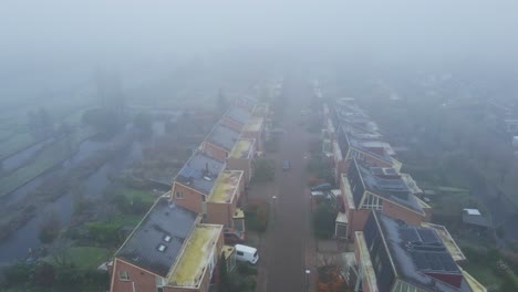 Aerial-of-a-beautiful-street-covered-in-mist---drone-flying-backwards