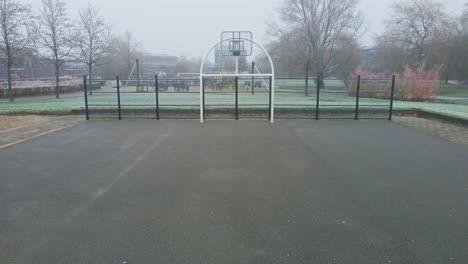 Drohne-Fliegt-In-Einem-Nebelbedeckten-Park-Auf-Den-Städtischen-Basketballplatz-Zu