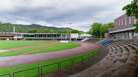Training-ground-with-small-grandstand-and-lightweight-athletics-track-under-cloudy-skies