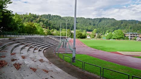 Training-ground-with-small-lonely-grandstand-and-lightweight-athletics-track-under-cloudy-skies