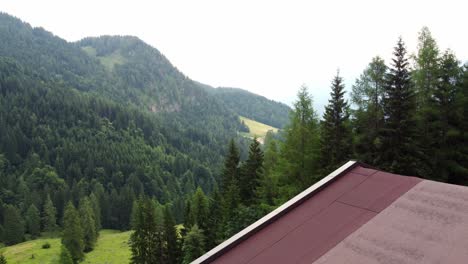 Small-hut-surrounded-by-green-fields-and-trees-in-the-Alps-in-Lofer,-Austria