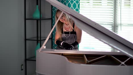 Beautiful-Model-sits-at-piano-posing-and-plays-keys-in-a-goofy-way-to-laugh