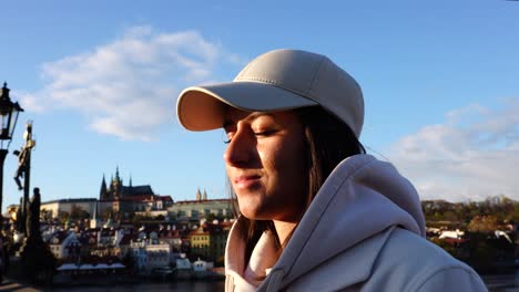 Girl-slowly-open-eyes-and-enjoy-Prague-city-on-Charles-bridge-during-sunset