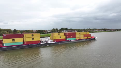 Wide-angled-aerial-side-view-of-goods-being-transported-along-river-water