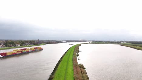Aerial-footage-flying-over-the-peaceful-Noord-River,-cargo-vessels-sailing