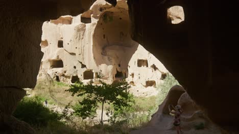 Tourist-explores-dark-rock-house-cave-Zelve-open-air-museum