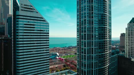 Nach-Unten-Kippbare-Antenne---Jay-Pritzker-Pavillon-Amphitheater-Und-Die-Bohne-Zwischen-Zwei-Wolkenkratzern-In-Der-Innenstadt-Von-Chicago,-USA