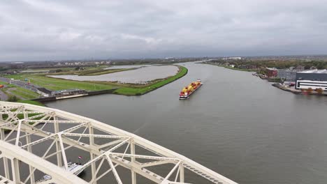 Imágenes-Aéreas-De-Gran-Angular-De-Un-Puente-De-Acero-Y-Un-Buque-De-Carga-Cargado