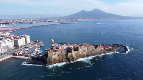 Aerial-View-Of-Ancient-Fortress-Near-City-And-Pier-In-Naples,-Italy---Drone-Shot