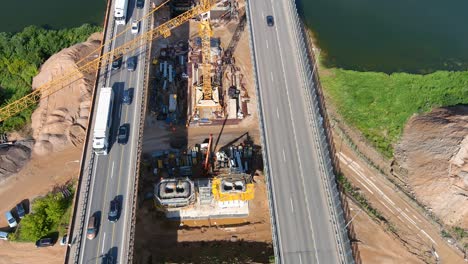 Heavy-machinery-constructing-middle-bridge-in-Kaunas,-aerial-view