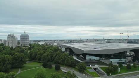 Aerial-panning-right-across-the-Munich-city-skyline,-BMW-Museum-revealed