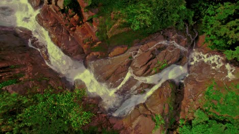 Drone-top-shot-of-a-waterfall-falling-on-red-rocks-in-the-Bijagual-ecological-reserve-in-Costa-Rica