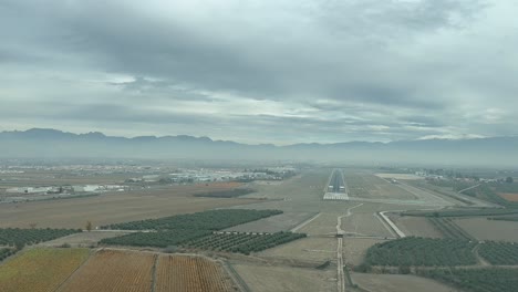 Real-time-landing-at-Granada-Airport,-Spain,-as-seen-by-the-pilots-from-the-cockpit-in-a-cold-winter-hazy-morning