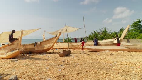 Schwarzafrikanische-Tischler-Arbeiten-An-Neuen-Holzbooten-Am-Strand,-Ghana