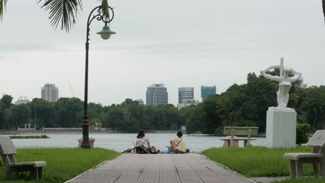 Dos-Madres-Y-Sus-Hijos-Disfrutan-De-Una-Tarde-Relajante,-El-Parque-De-La-Ciudad-De-Hanoi