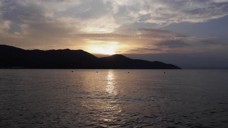 Ruhiger-Zeitraffer-Sonnenuntergang-über-Dem-Meer-Mit-Faszinierenden,-Lebendigen-Farben-Und-Ruhigem-Wasser