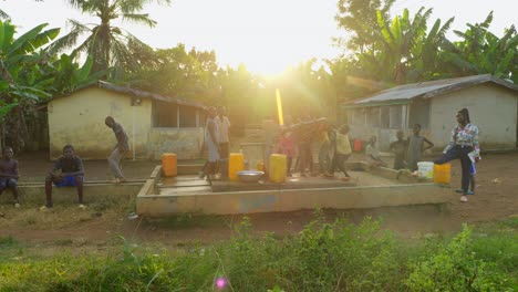 Niños-Recogiendo-Agua-Jugando-Y-Bailando-Con-Una-Bomba-De-Agua-En-Una-Remota-Aldea-De-África-Al-Atardecer